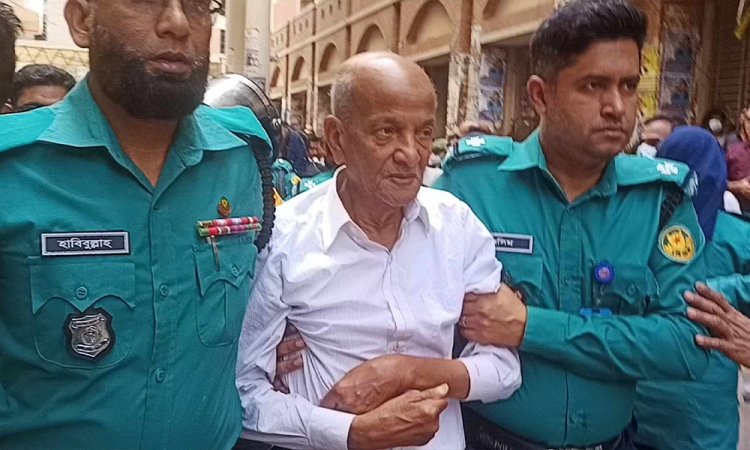 কাঠগড়ায় বুকে হাত বেঁধে দেয়াল ঘেঁষে দাঁড়িয়ে ছিলেন কামাল মজুমদার